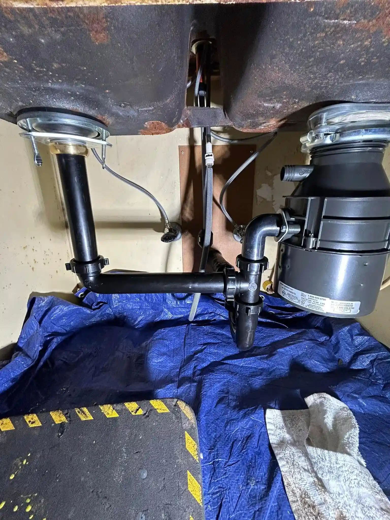 Garbage disposal plumbing repair in progress under a kitchen sink in Chula Vista
