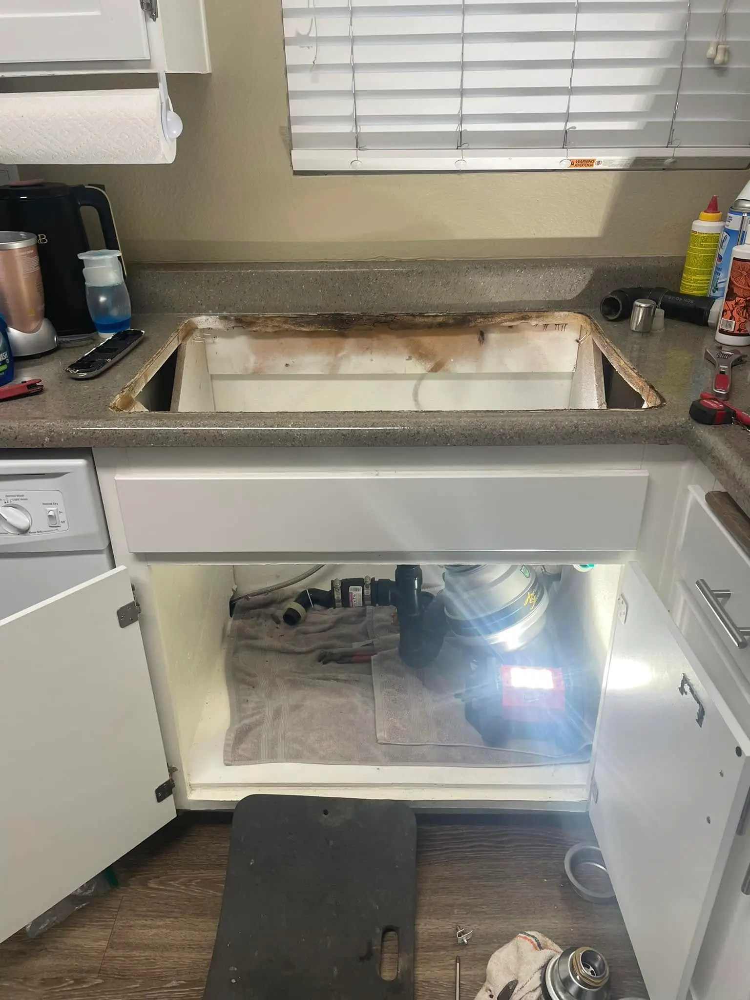 Under-sink plumbing access showing disposal connections in a Chula Vista kitchen