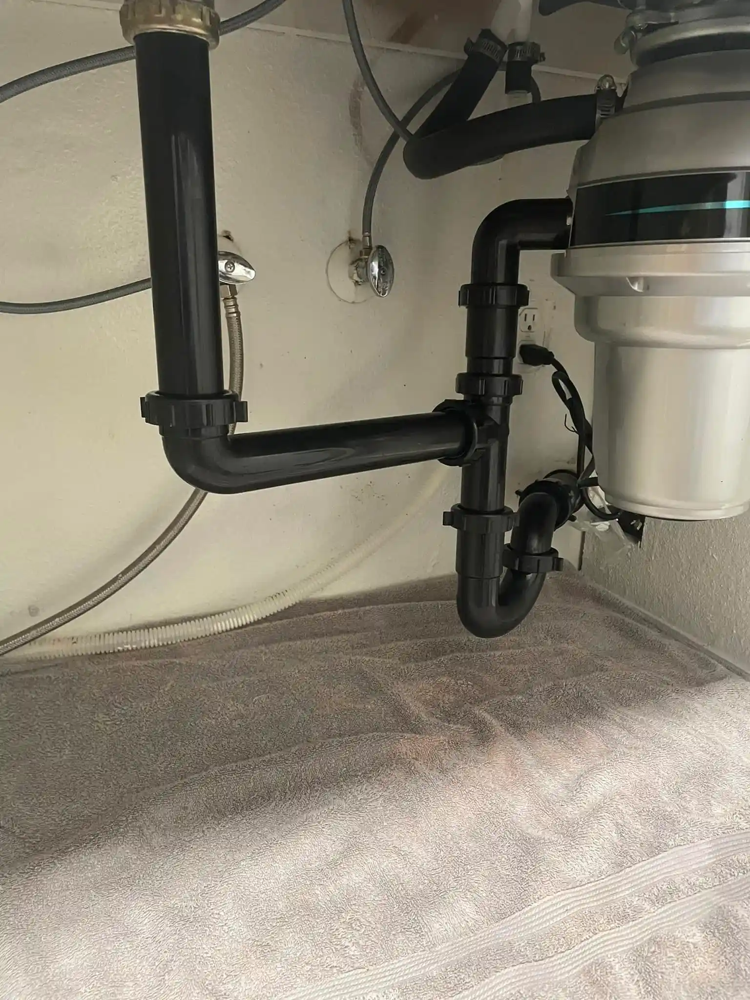 Under-sink drain plumbing and disposal connections in a Chula Vista home