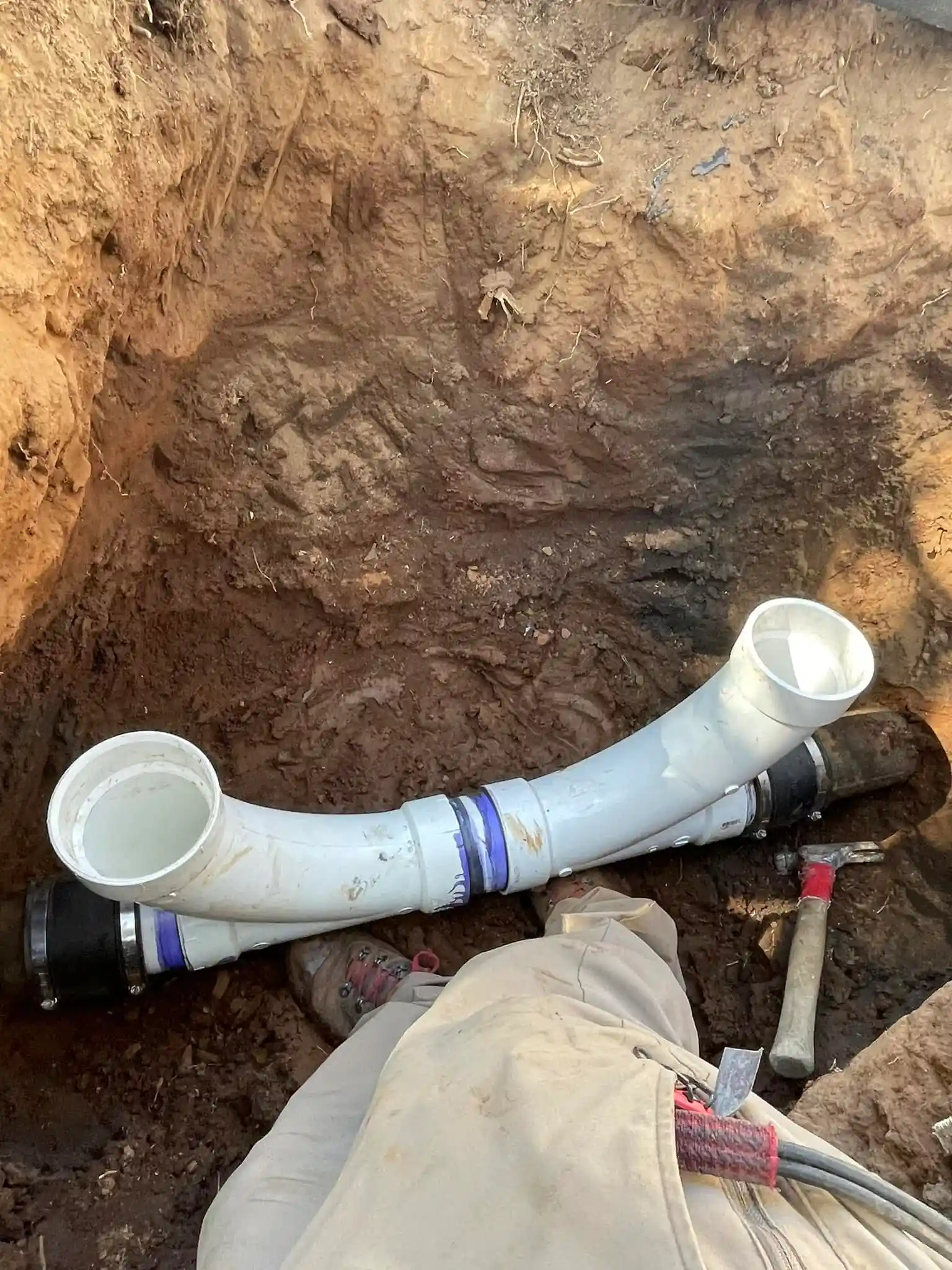 Excavated PVC drain line being repaired underground at a Chula Vista property